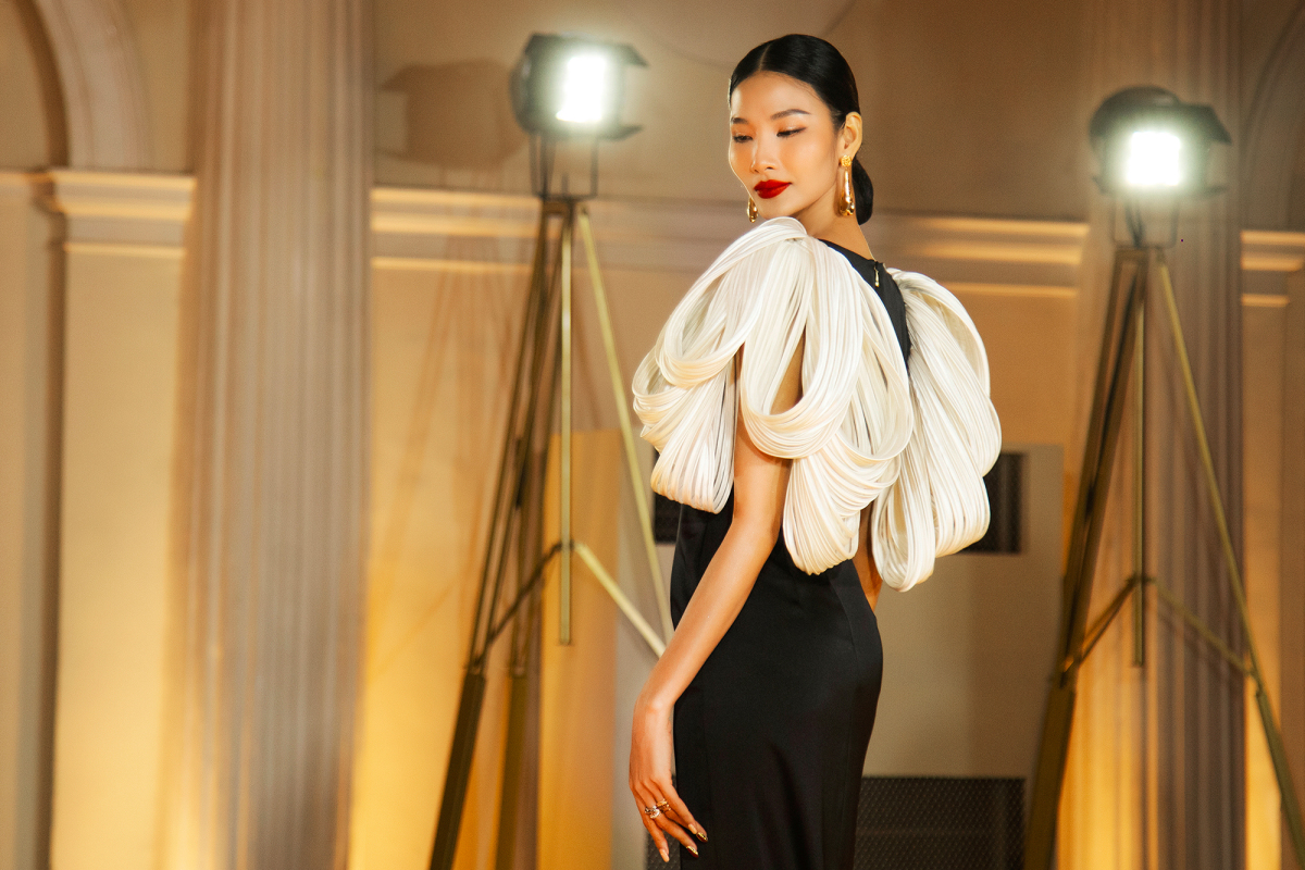Model Hoang Thuy dons a black gown with exaggerated sleeves.
