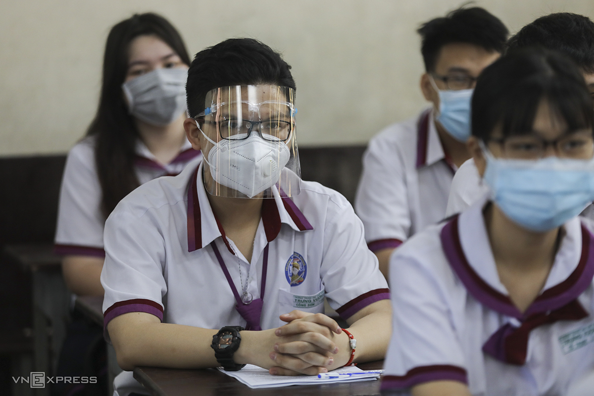 Twelfth grader Cong Son at Trung Vuong High School wears a face shield over his mask. This is our last year studying together so returning to school would give us the chance to have more memories of each other. But still, the ongoing outbreak makes me worried, he said.