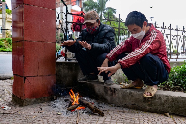On a street in Long Bien, under the cold of 12 degrees Celsius, many workers find warmth by lighting a fire.