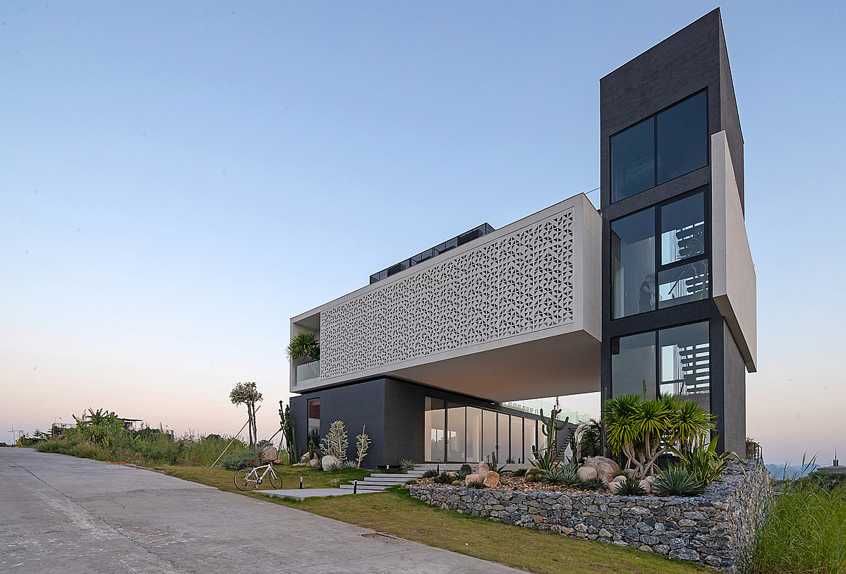 Four blocks alternately create openings for ventilation, maximizing and diversifying views of the bay while meeting different usage needs of the homeowners. The base of the villa is surrounded by different vegetation, including reed grass, cactus and others to make the house blends in with the surrounding landscape.