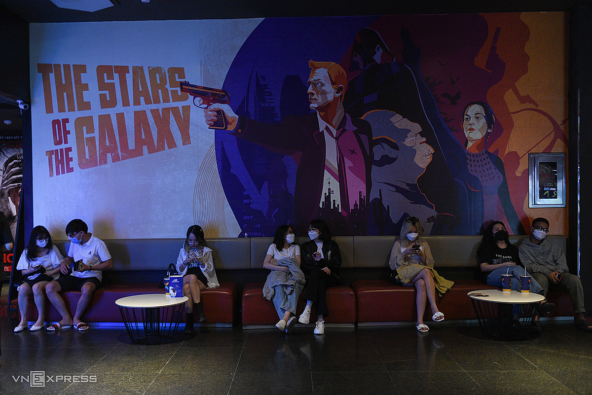 People at a waiting lounge inside a movie theater.
