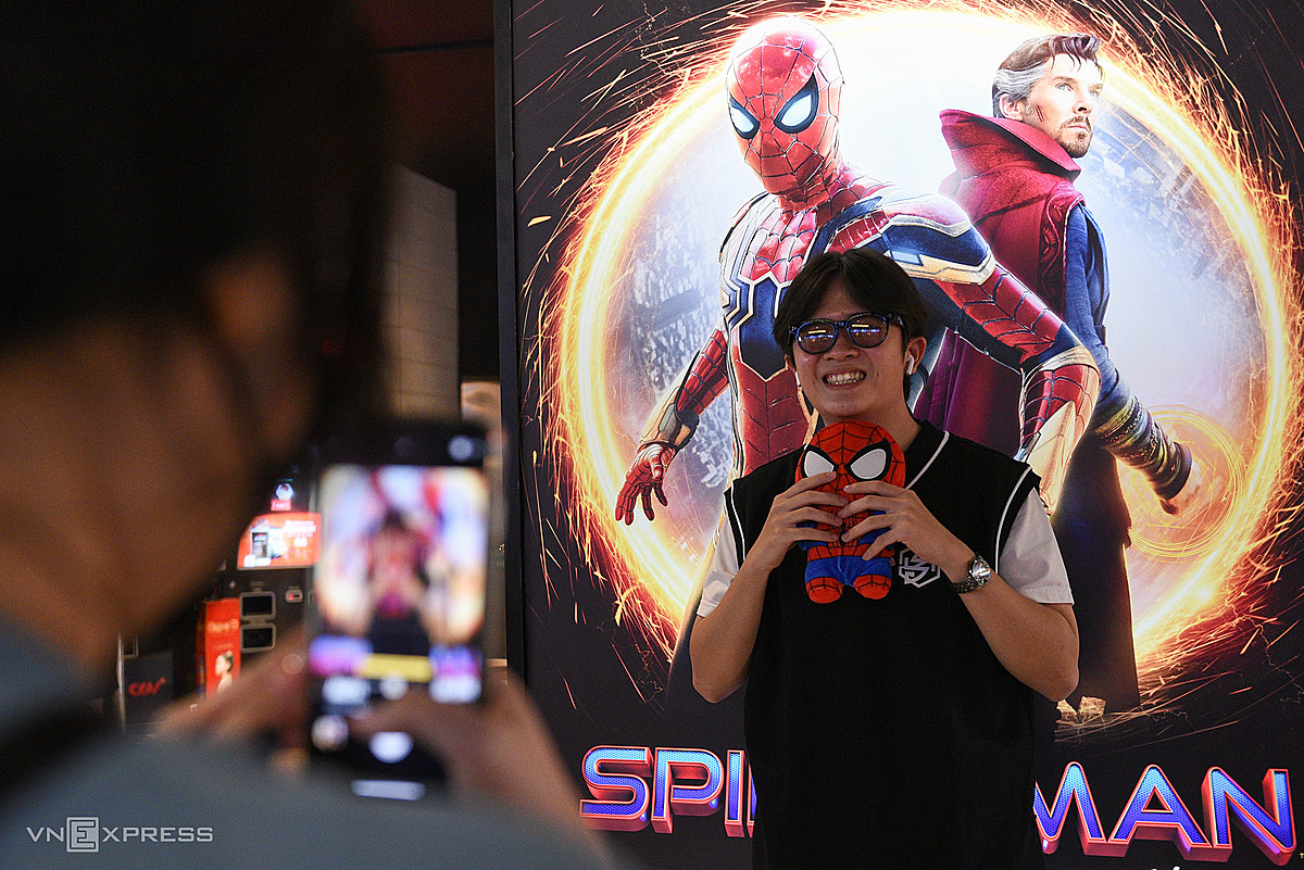 A Spider-Man fan arrives at the theater early to take photos next to the movie poster at the CGV Cinema in HCMCs District 7, Dec. 19, 2021. Photo by VnExpress/Nhat Thuc