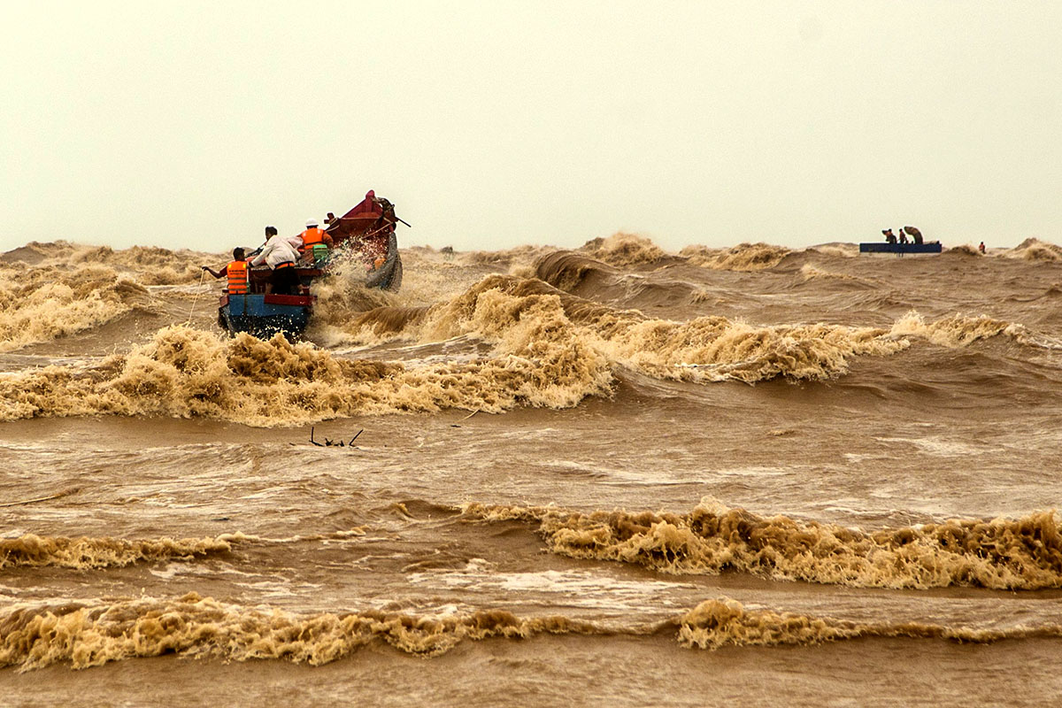 Tran Van Khoi (wearing the white helmet) on a fishing boat with local fishermen during an attempt to rescue stranded crew members of the Vietship 01 vessel on October 10, 2021. Photo by VnExpress/Bao Trung