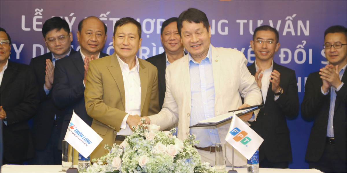 Co Gia Tho in a brown suit, chairman of Thien Long Group, and Truong Gia Binh, chairman of FPT, at a signing ceremony. Photo by Thien Long