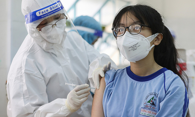 A medic inoculates Covid-19 vaccine to a high school girl in District 1, HCMC, Oct. 27, 2021. Photo by VnExpress/Quynh Tran