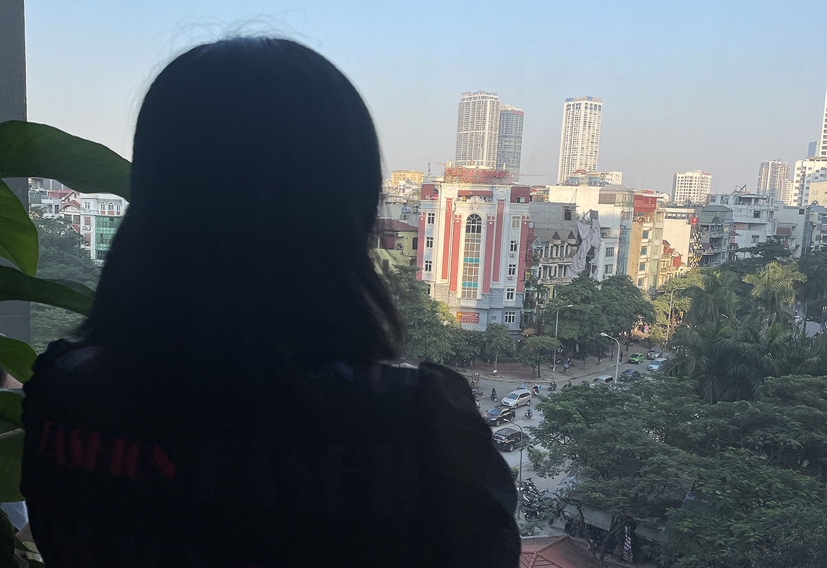 Le Thu Hong is seen looking out the window from her workplace in Hanoi in December 2021. Photo by VnExpress/Phan Duong