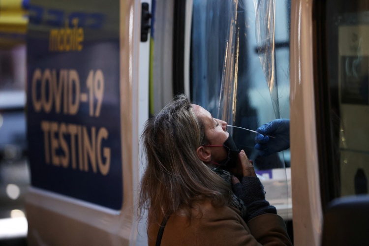 A person takes a COVID-19 test on Broadway as the Omicron coronavirus variant continues to spread in Manhattan, New York City, U.S., December 27, 2021. Photo by Reuters