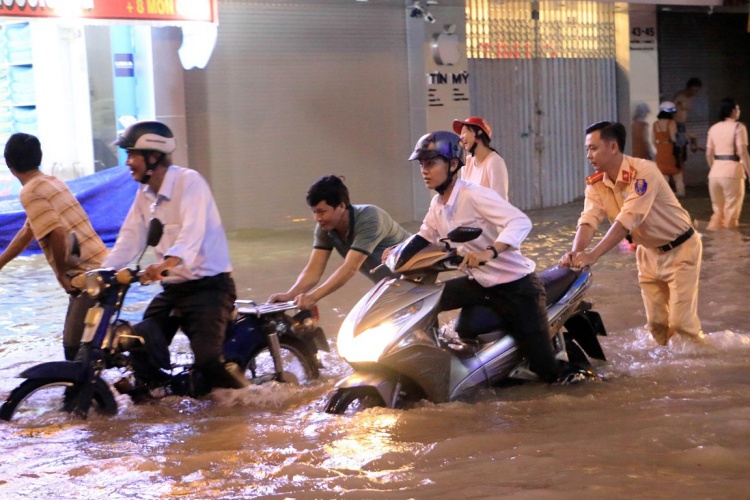 Police officers help residents in flood in Vinh Long city in 2019. Photo by Vietnamplus