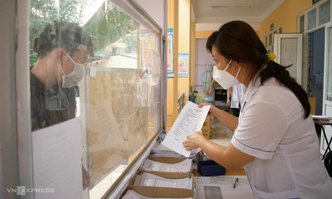 A ward medical staff in Hanoi guides a man about the medical declaration process for suspected cases on Dec. 21, 2021. Photo by VnExpress/Chi Le