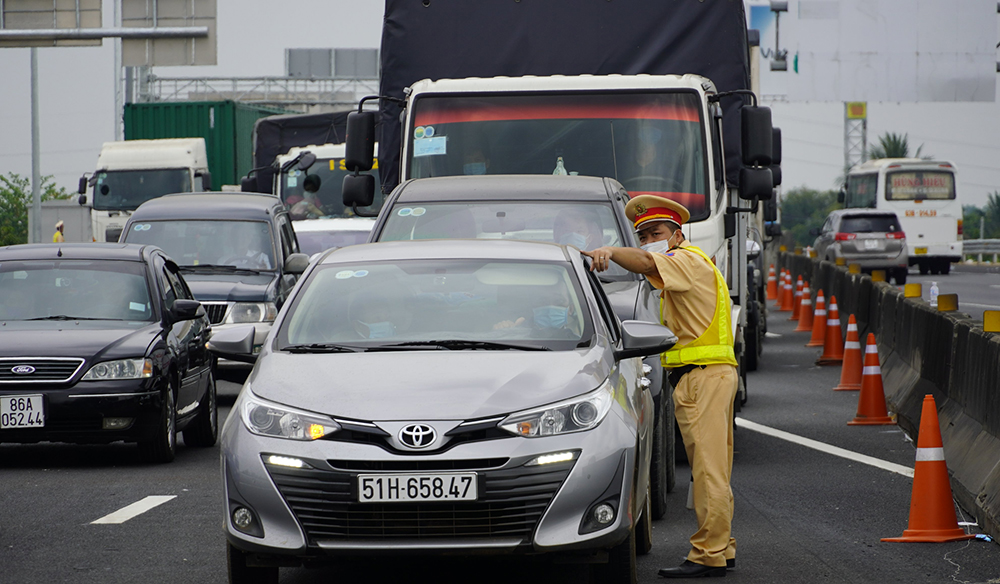 A traffic police officer guides a driver to circulate traffic and ease congestion on the Trung Luong - My Thuan Expressway, January 25, 2022. Photo by VnExpress/Hoang Nam