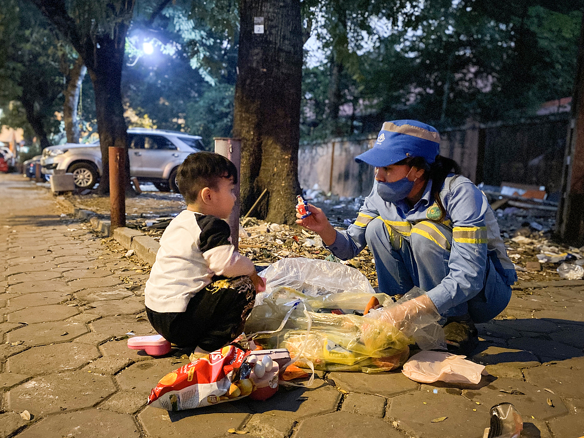 Lan and her son look for abandended toys in a garbage bag on Dec. 25, 2021. Photo by VnExpress/Quynh Nguyen