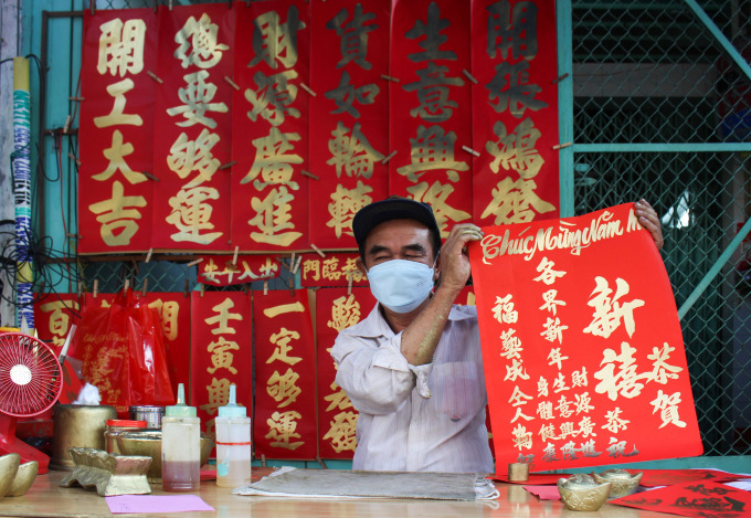 Cau holds up a lien he wrote for Vien that has wishes like health, prosperity and luck. Photo by VnExpress/Diep Phan