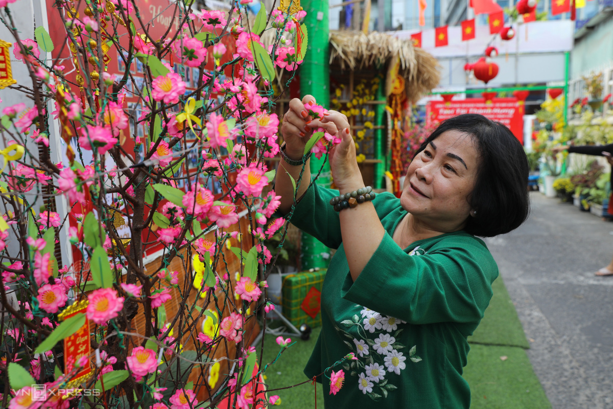 Cam adds a few more flowers on the branch of a fake peach blossom tree.The head of the neighborhood said he is not afraid that these decorations will be stolen since this is a safe neighborhood and there is a civil defense hut right at the entrance.