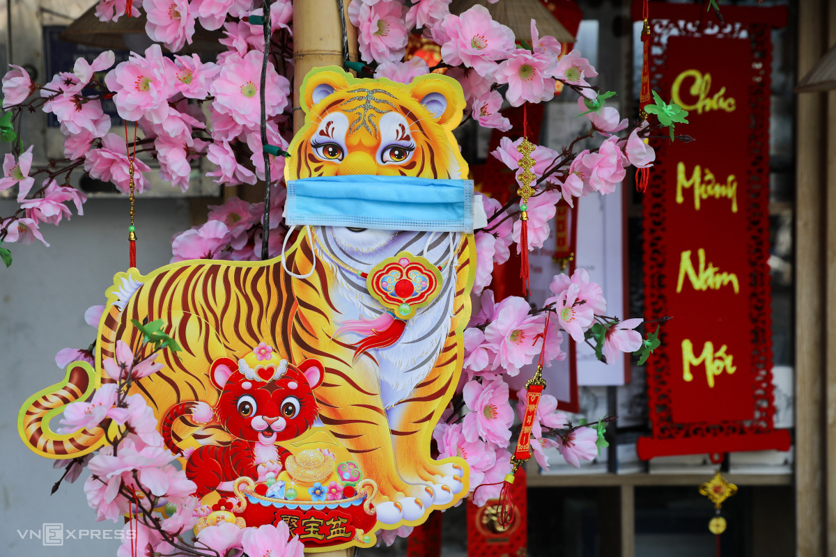 Du put a face mask on a tiger decoration, the zodiac sign for 2022 Lunar New Year, to remind people not to forget to practice Covid preventition measures.
