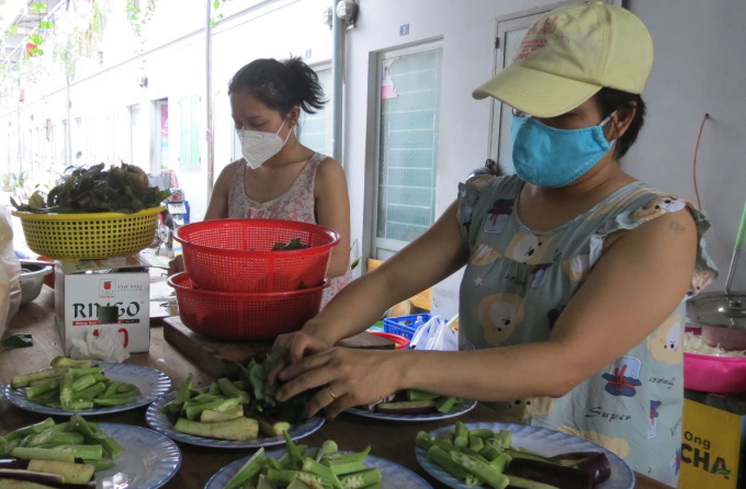 Nguyen Thi Huyen (L) prepares food for the year-end party with her neighbor on Jan. 22, 2022. Photo by VnExpress/Le Tuyet