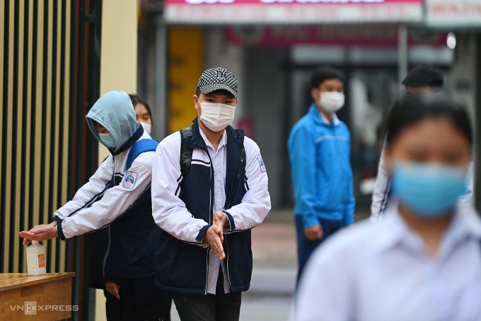 Ninth graders students of Ba Vi High School disinfect their hands on their first day heading back to school on Nov. 8, 2021. Photo by VnExpress/Giang Huy