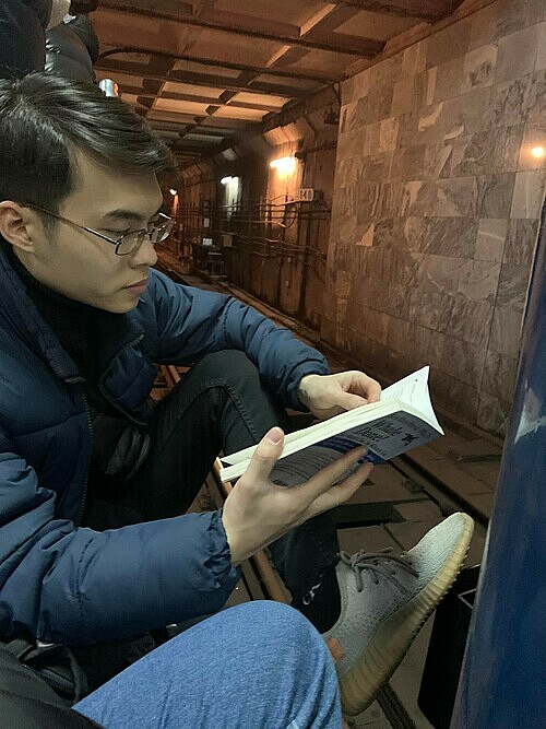 Anh’s husband keeps calm and reads a book while sheltering in a subway station in Kharkiv, Ukraine. Feb. 24, 2022.
