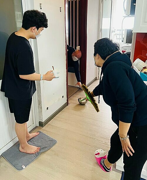 Covid-infected mother and son hand food to the father, who tested negative for the virus, in their apartment in Hanoi, February 2022. Photo acquired by VnExpress