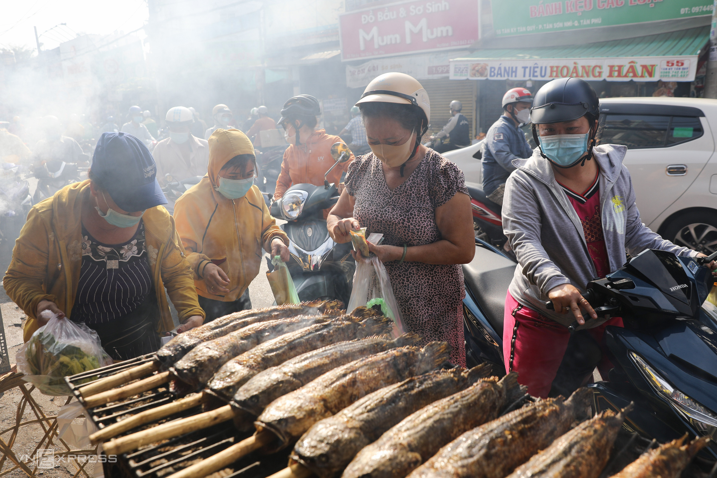 Smoke fills a corner of the street, which was packed with customers since Thursday morning.Depending ont the size, the price for each grilled snakehead fish ranges between VND170,000-200,000 ($7.49-8.81). This price, according to many stalls, increased slightly over the previous year.