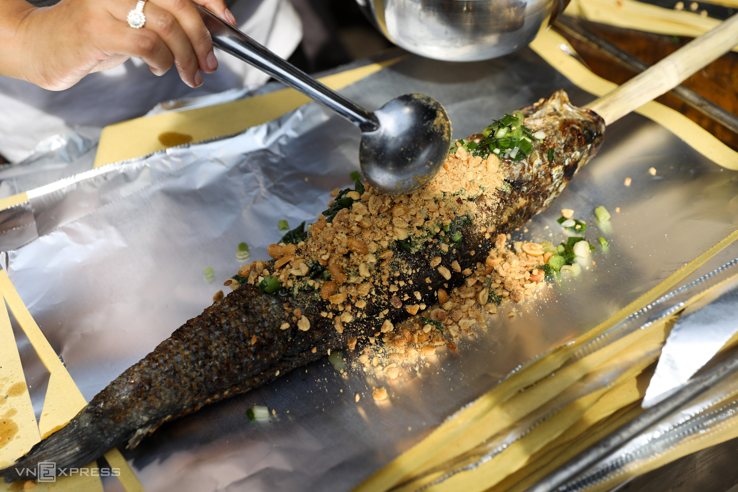 After the customer has finished selecting the fish, it will be garnished with green onion and roasted peanuts before being wrapped in foil. According to the tradition, worshippers must offer a whole fish without scraping off the scales or removing the tail