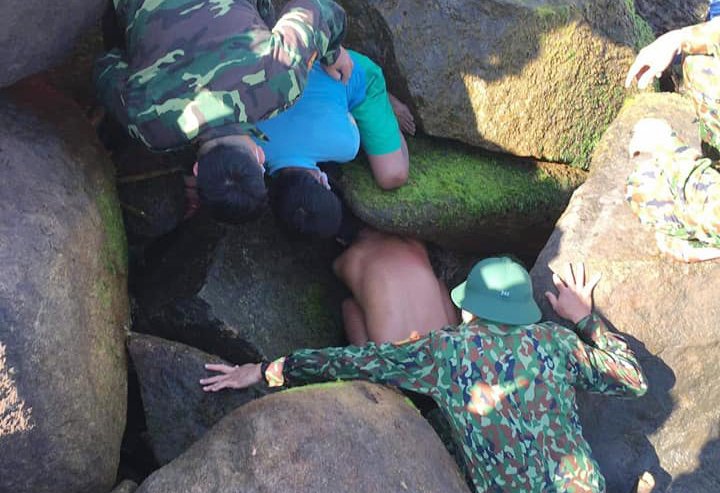 Rescuers try to remove a boys body from rocks on the shore of Hoi An, February 28, 2022. Photo by VnExpress/Phuong Hong