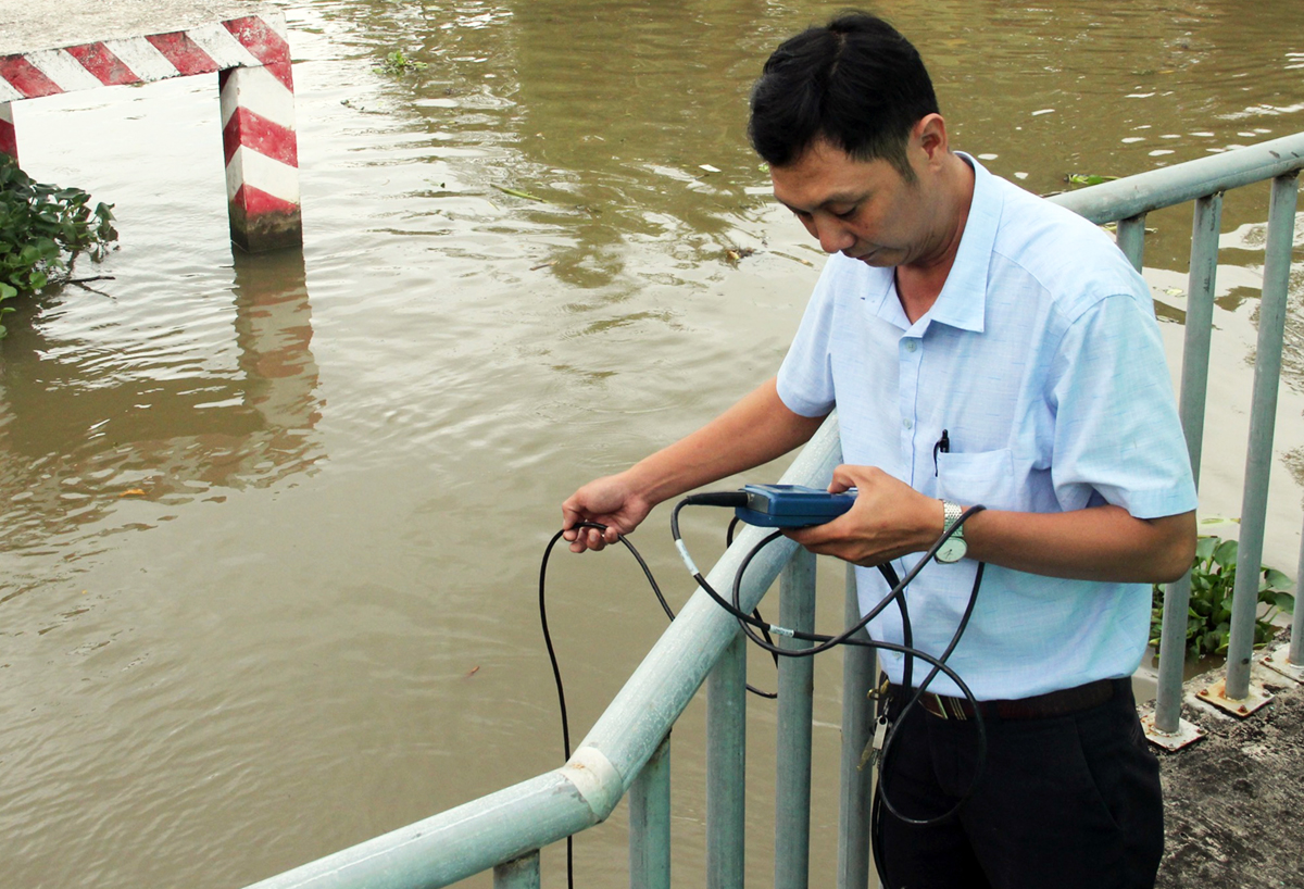 An official from the Department of Agriculture and Rural Development in Bac Lieu Province measures the salinity level on a canal in the province, February 2022. Photo by VnExpress/Cuu Long