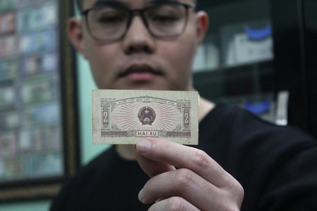 Hung and the 2 xu, the smallest banknote ever issued in Vietnam. Photo by VnExpress/Quynh Nguyen