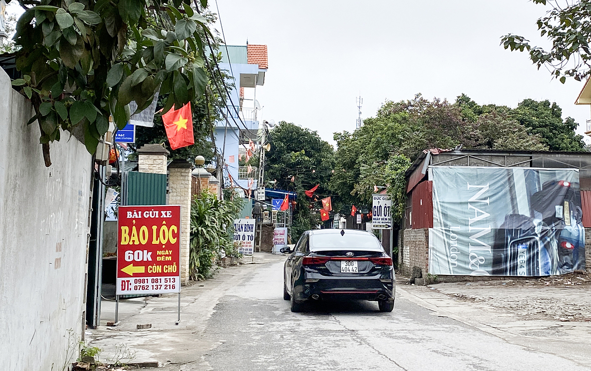 A car enters Tan Trai Village, where there are many parking lots along the way. Photo by VnExpress/Quynh Tran