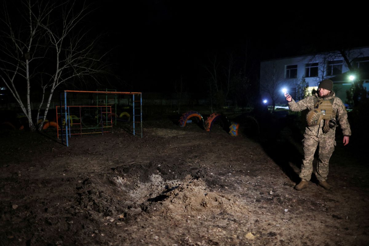 A Ukrainian soldier stands at a playground outside a kindergarten, which according to Ukraines military officials was damaged by shelling, in Stanytsia Luhanska, in the Luhansk region, Ukraine, February 17, 2022. Photo by Reuters/Carlos Barria