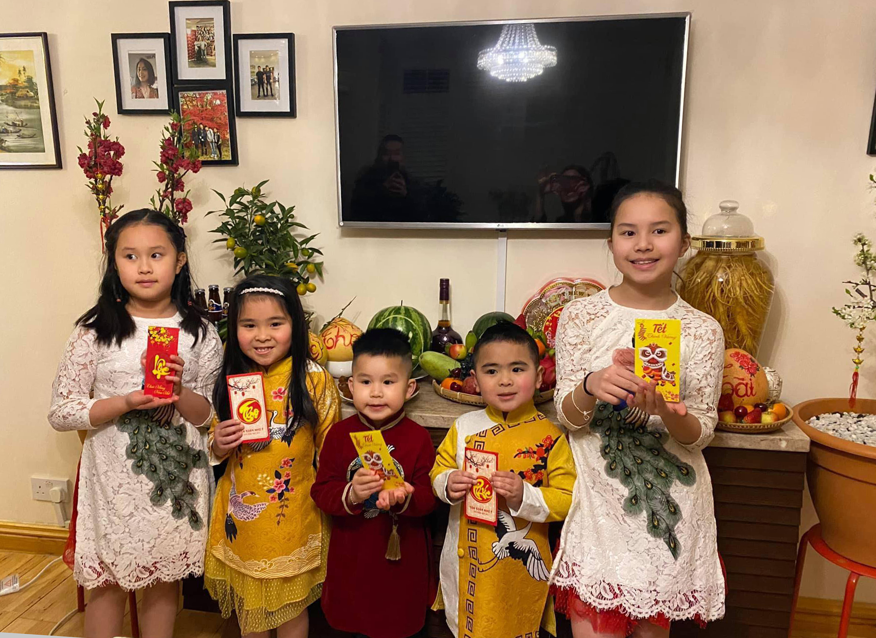 Children from Vinh Le and his friends families in the U.K. pose for a photo in Vietnamese traditional dress and with Tet lucky money li xi. Photo courtesy of Vinh Le