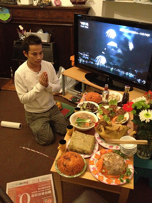 Vinh Le prays by a table of Tet offerings at his home in the U.K. Photo courtesy of Vinh Le