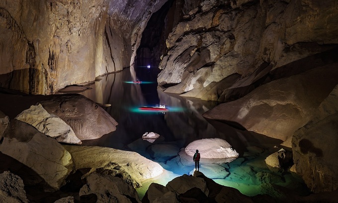 A tourist takes a boat across a river inside Son Doong Cave in Quang Binh Province, 2021. Photo by Ngo Tran Hai An
