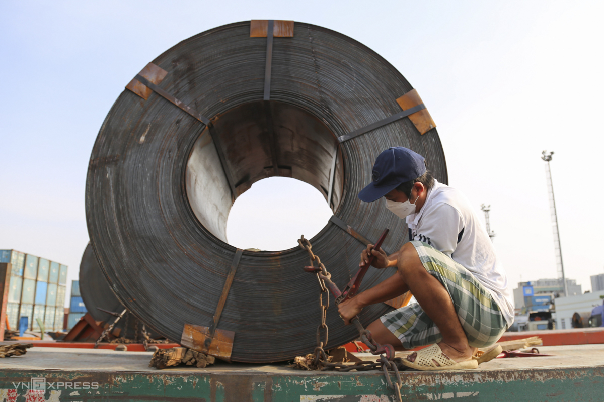 Nguyen Trong Nhon, 39, a tractor driver secures a 20-ton steel coil with a diameter of 2m to his vehicle. Nhon admitted there are no mandatory requirements related to securing the coils when transporting them.   Other drivers taught me how to do it, and I [also] learned from experience. When I feel the chain is tight enough, I’ll drive, he said.