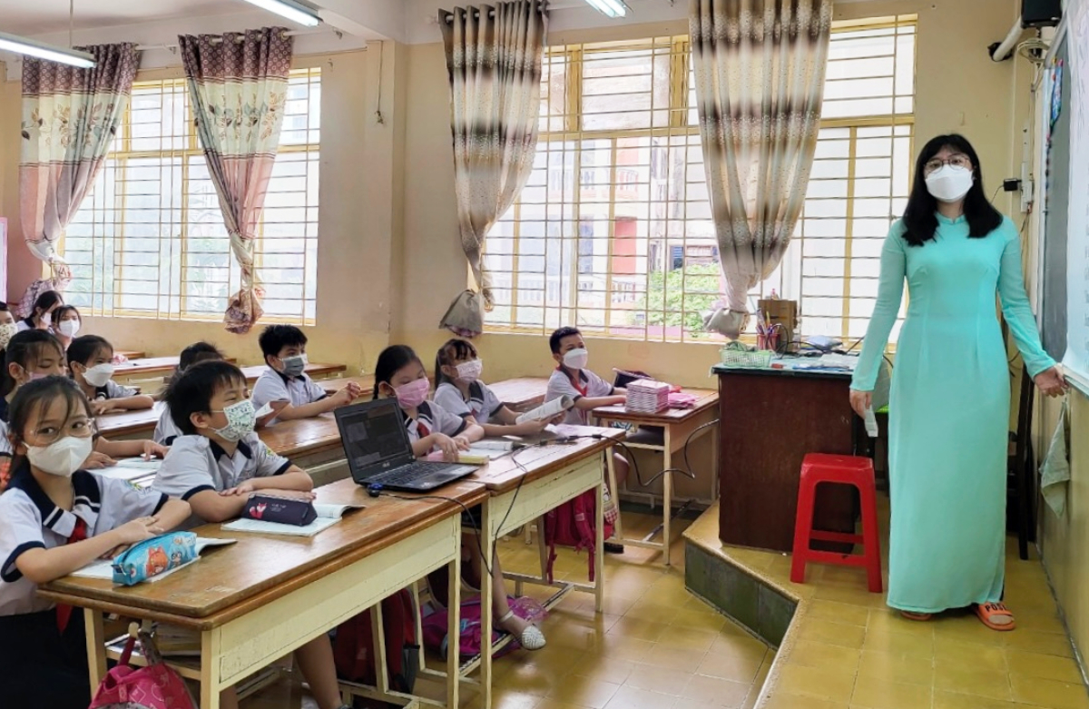 Hoang Thuy Lan Anh, homeroom teacher of class 4/7 of Phan Dinh Phung Primary School, hold a in-person class for 21 students in the classroom and 28 students at home.