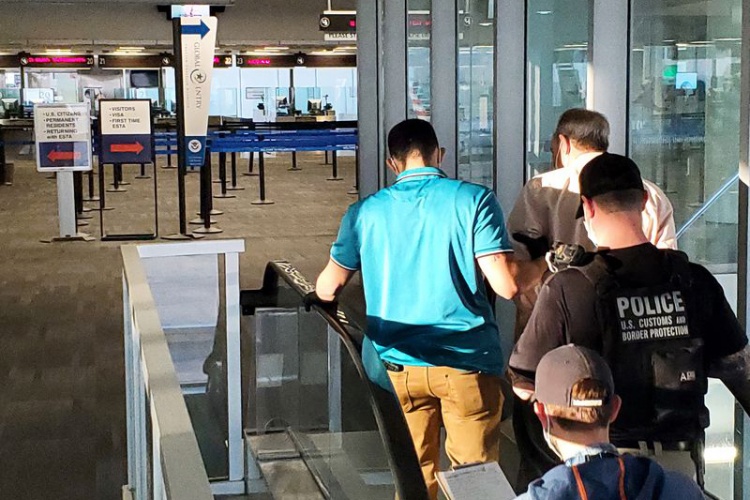 Michael Pierre Boumal, fist right, is taken into custody Jan. 19, 2022, at Philadelphia International Airport. Photo courtesy of U.S. Customs and Border Protection