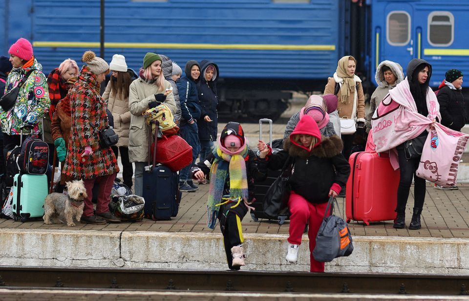 Refugees crossing the rail tracks as they try to reach trains to Poland following Russia’s invasion of Ukraine at the main train station in Lviv, Ukraine, March 4, 2022. Photo by Reuters