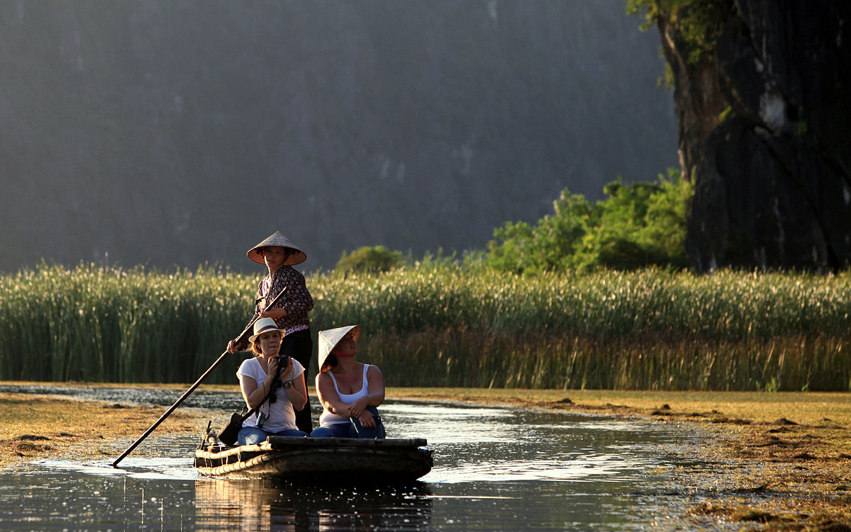 Foreign tourists sit on a boat to capture the endangered Delacour’s langurs in Van Long Lagoon, Ninh Binh Province. Photo by VnExpress/Le Bich