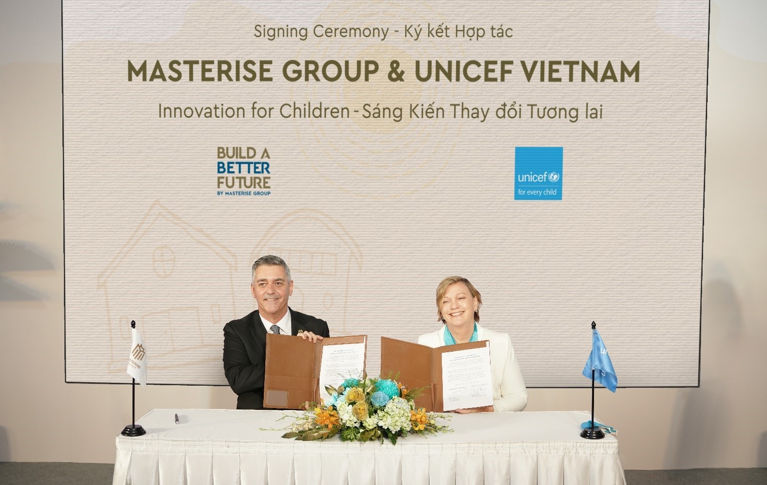 Jason Turnbull (L) and Rana Flowers, UNICEF representative to Vietnam, sign a long-term strategic partnership. Photo by Masterise Group