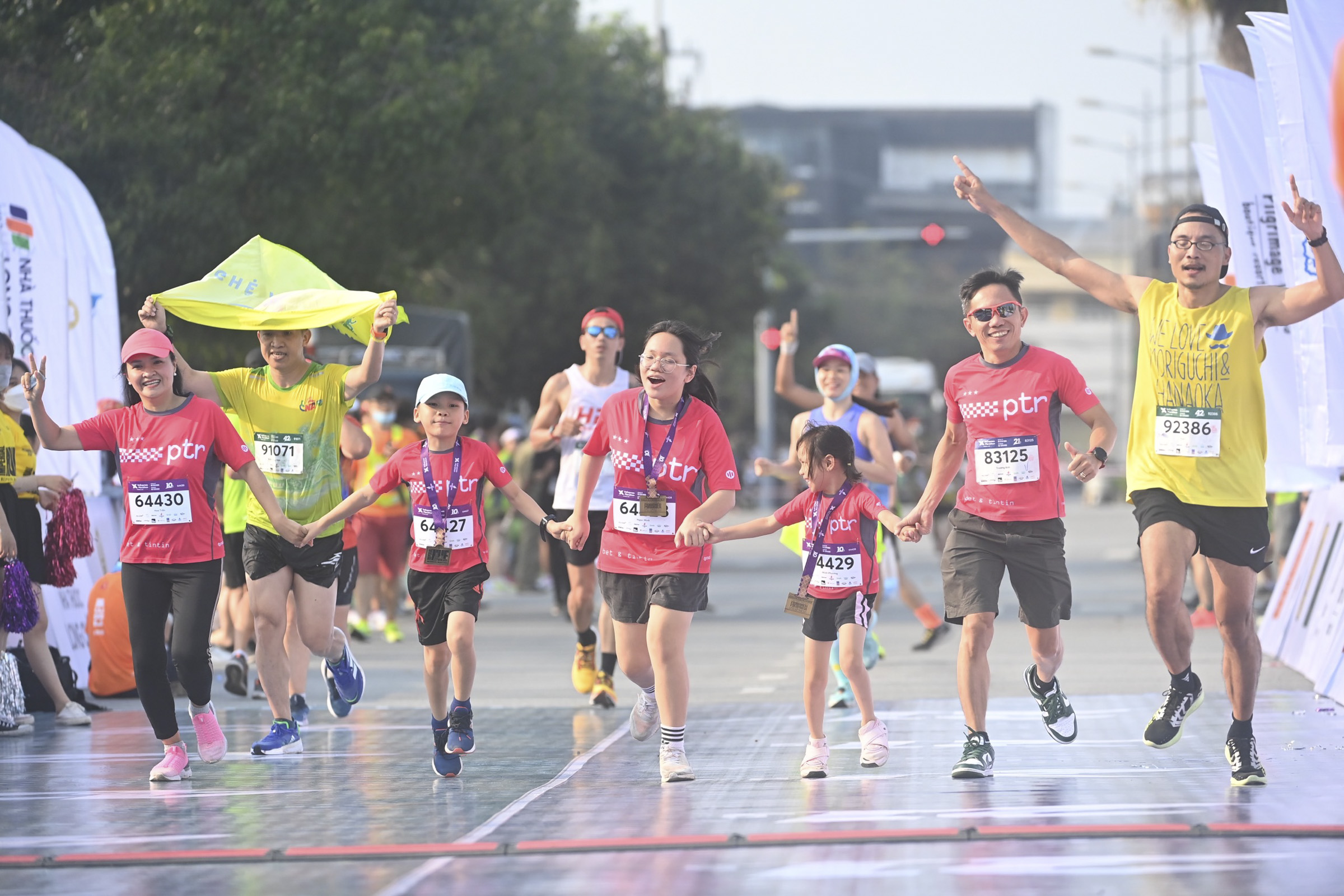 A family of five (in red) crosses the line together after finishing a 10-km run.