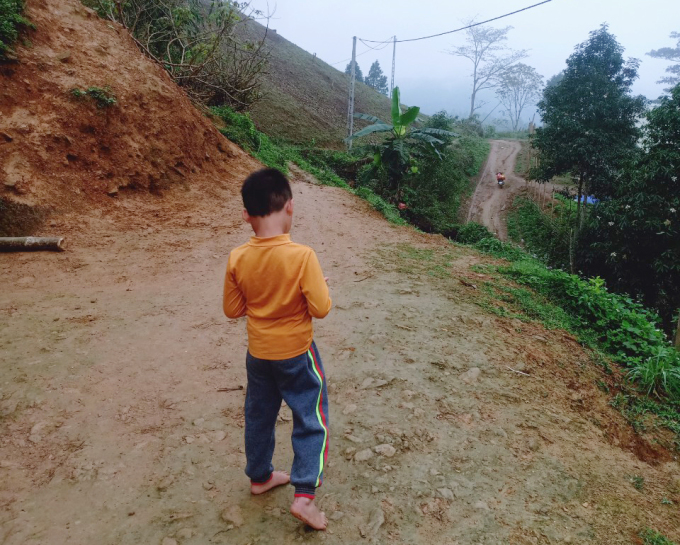 Huy, 6, walks down the muddy road in the rural district of Ba Be in Bac Kan Province, March 2022. Photo courtesy of Pao