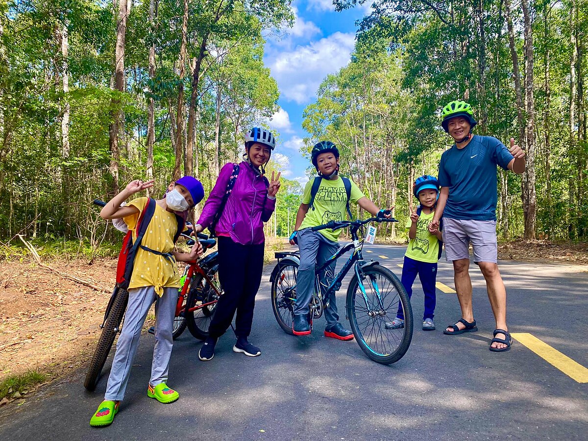 A family cycle through a primeval forest inside Thac Mai trekking area in Dong Nai Province. Photo by Thac Mai Adventures