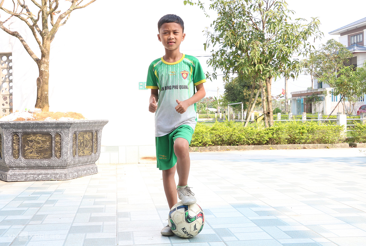 Gia Hung practices football in his front yard. Photo by VnExpress/Duc Hung