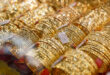Gold prices inch down from historic peak